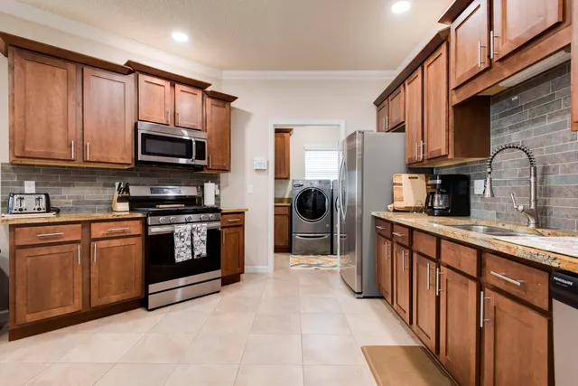 a living room with furniture a fireplace and a kitchen view