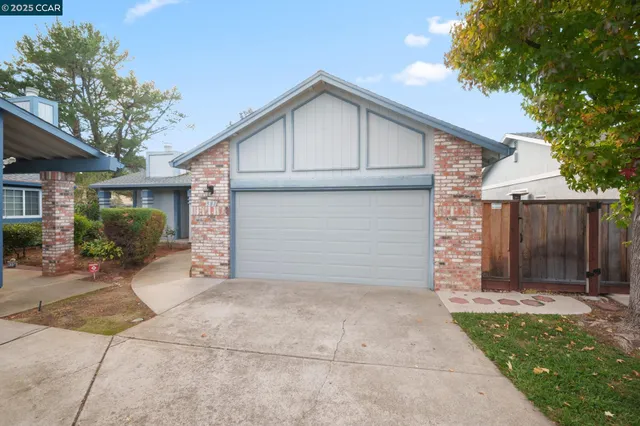 a view of backyard of house with wooden fence and large trees