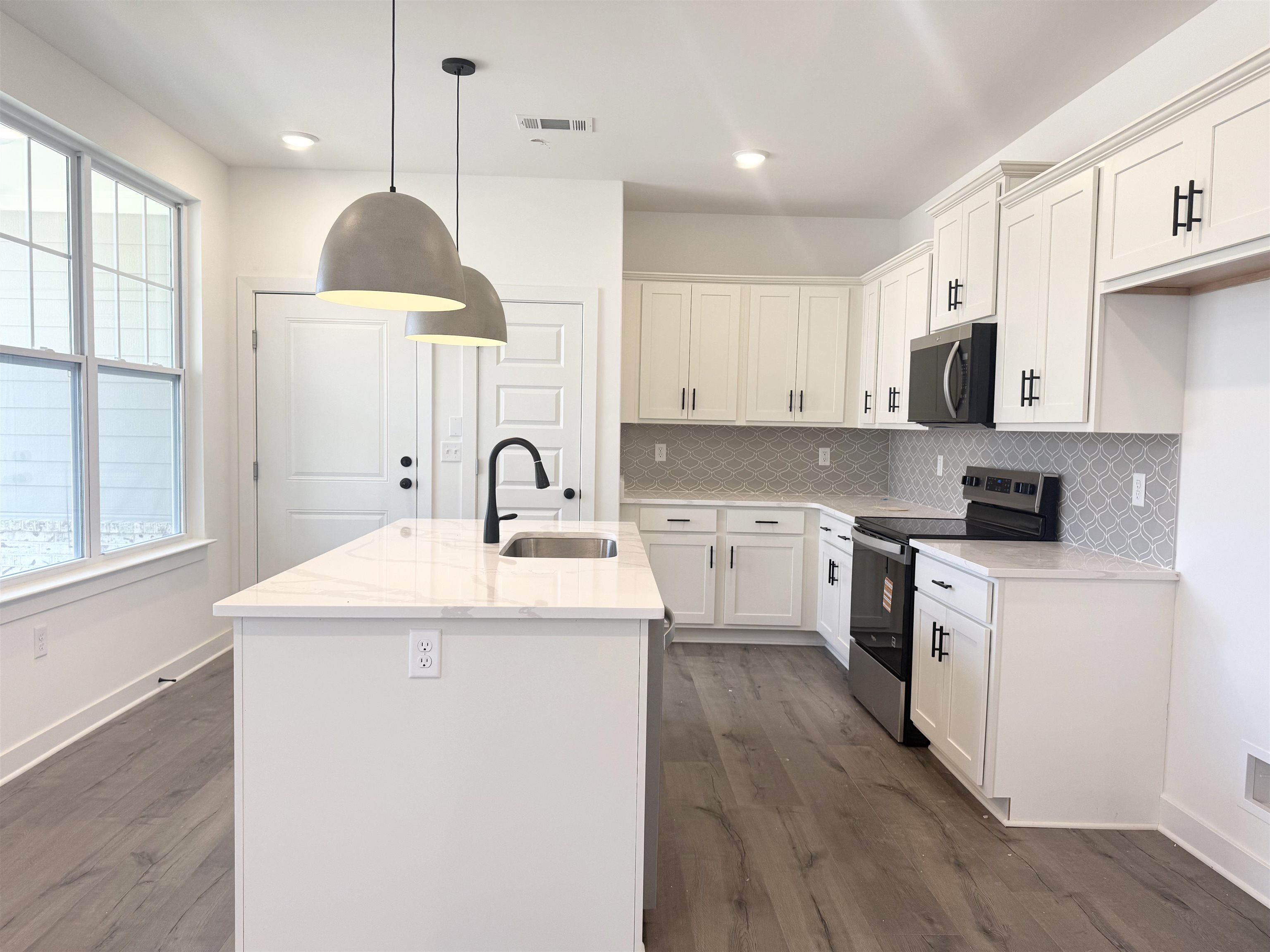 3060 Portage Drive Bartlett, TN 38133 - Photo 11 of 21 a kitchen with a sink a stove a refrigerator and white cabinets