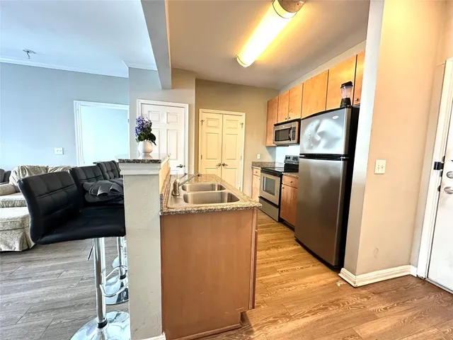 a kitchen with stainless steel appliances granite countertop a refrigerator a stove and a sink