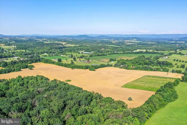 an aerial view of a houses with a yard and lake view