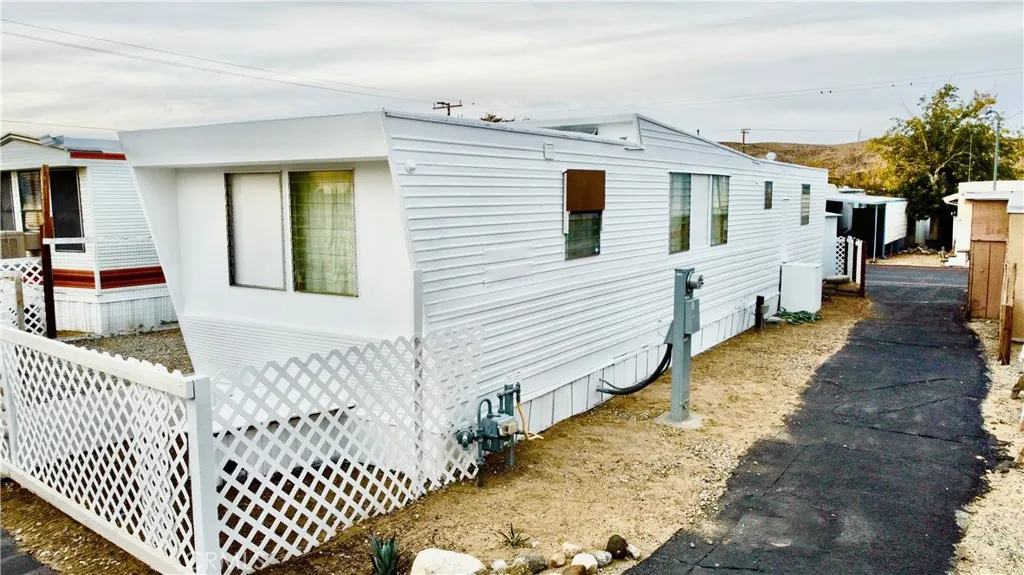 6426 Valley View Drive, Unit 9 Joshua Tree, CA 92252 - Photo 2 of 23 a view of a white house with wooden fence