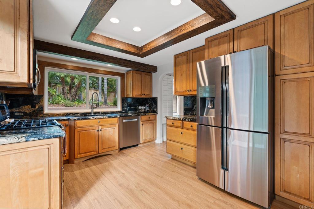612 Lucylle Lane Encinitas, CA 92024 - Photo 14 of 47 a kitchen with stainless steel appliances granite countertop a refrigerator a sink dishwasher a stove and white cabinets with wooden floor