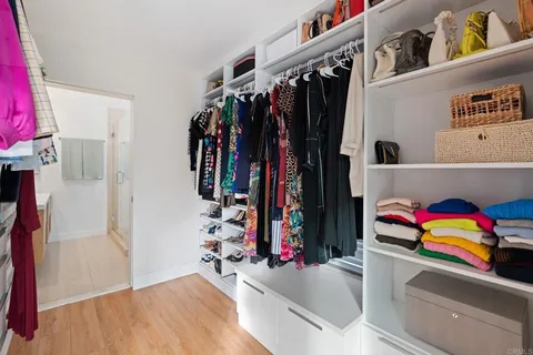 a view of walk in closet with clothes and shoes
