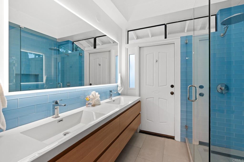 612 Lucylle Lane Encinitas, CA 92024 - Photo 21 of 47 a spacious bathroom with a shower sink and mirror
