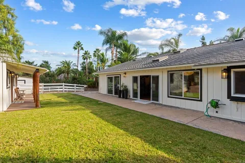 a view of a house with pool and sitting area