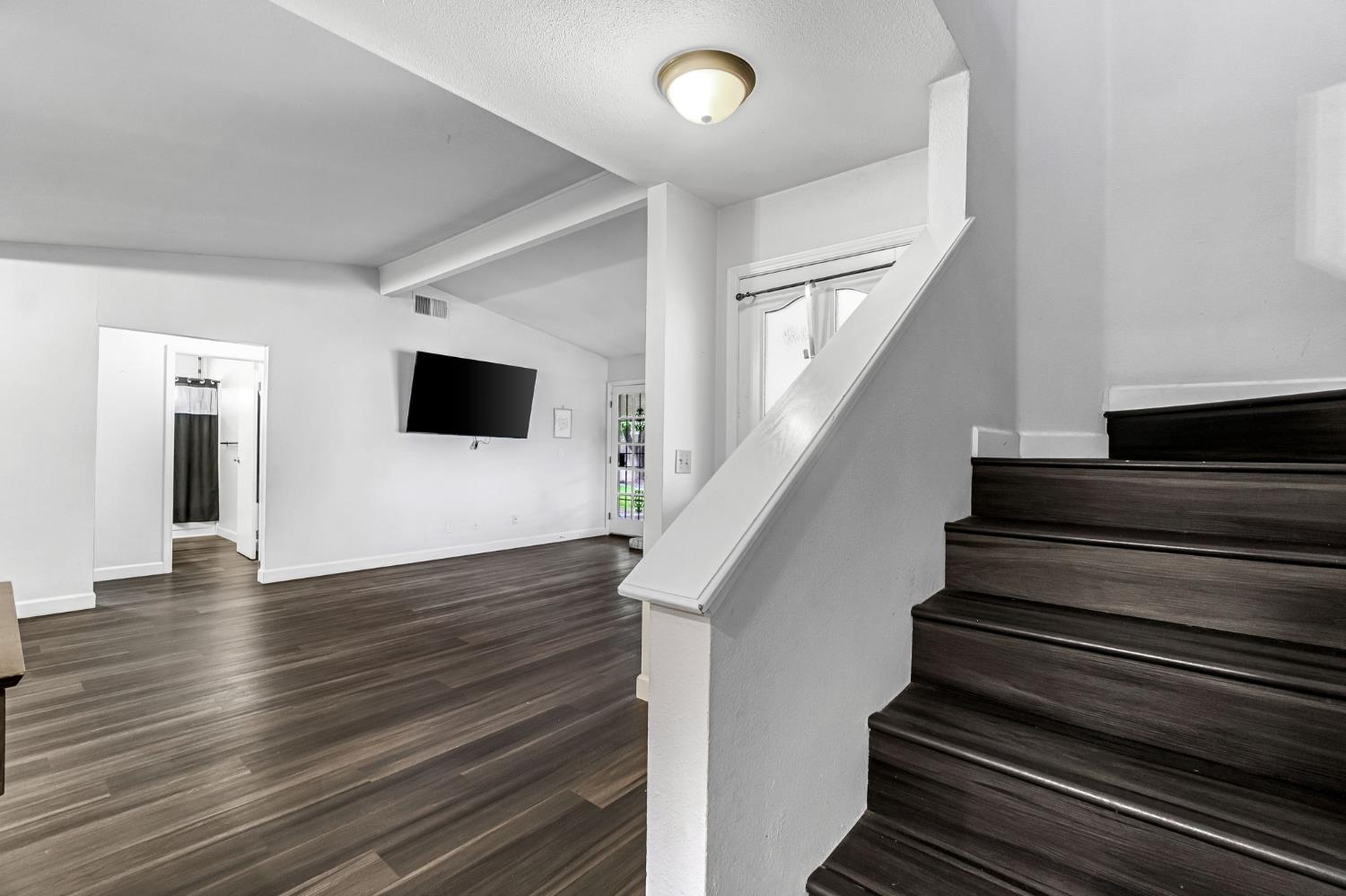 901 Valley Way Madera, CA 93637 - Photo 22 of 42 a view of an empty room with wooden floor and stairs
