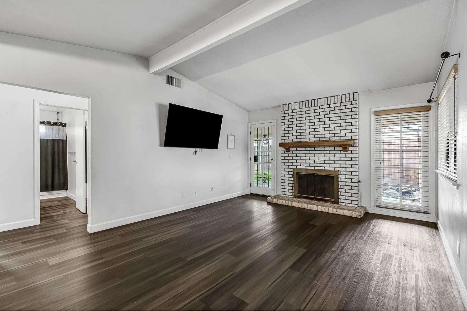 901 Valley Way Madera, CA 93637 - Photo 5 of 42 a view of a livingroom with wooden floor and a fireplace