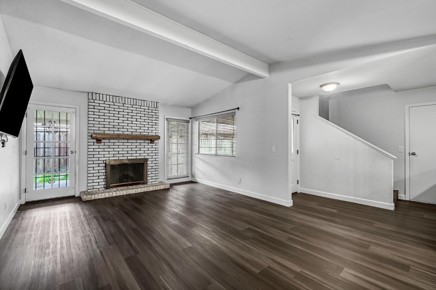 901 Valley Way Madera, CA 93637 - Photo 7 of 42 an empty room with wooden floor fireplace and windows