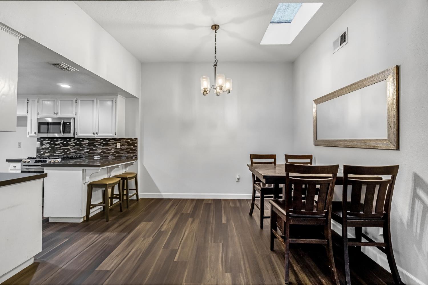 901 Valley Way Madera, CA 93637 - Photo 9 of 42 a kitchen with a table chairs refrigerator and microwave