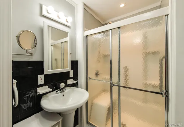 a bathroom with a sink a mirror a toilet and a shower