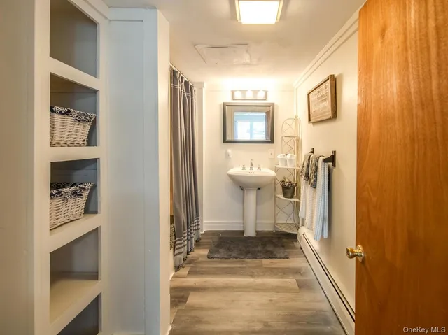 a view of a hallway with a toilet and a bathroom
