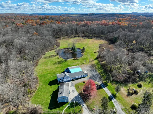 an aerial view of a house with a garden and lake view