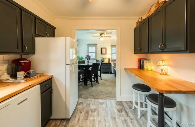 a kitchen with a refrigerator a stove and a dining table with wooden floor