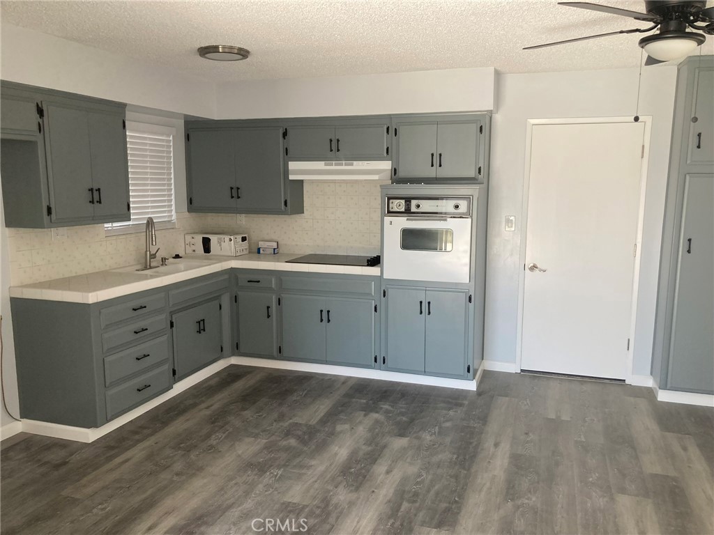 409 West Perdew Avenue Ridgecrest, CA 93555 - Photo 4 of 14 a kitchen with a sink cabinets and wooden floor
