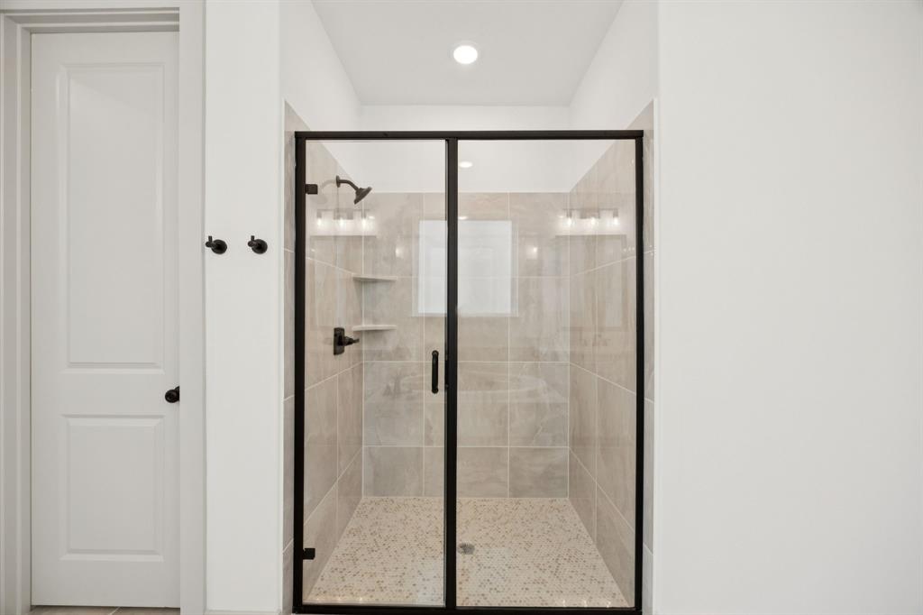 4180 Kestrel Street Prosper, TX 75078 - Photo 13 of 23 a bathroom with a glass shower door