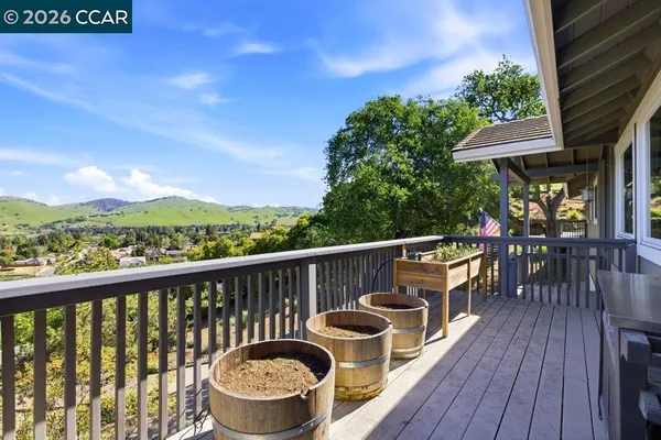 a balcony with wooden floor table and chairs
