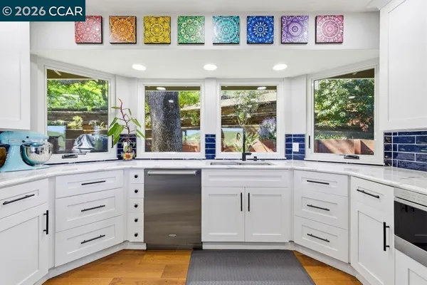 a kitchen with cabinets appliances and a large window
