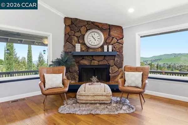 a living room with furniture a clock and a large window