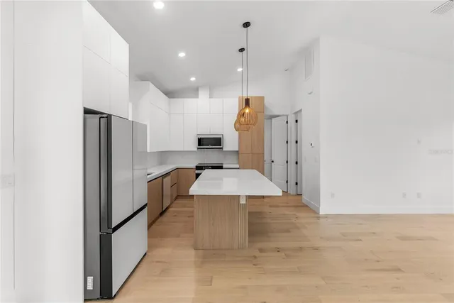 a kitchen with stainless steel appliances granite countertop a sink a stove and a refrigerator