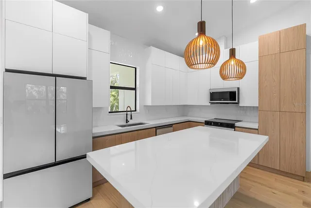 a kitchen with stainless steel appliances granite countertop a sink a stove and a refrigerator