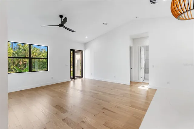 a large kitchen with stainless steel appliances granite countertop a stove a refrigerator a oven and a wooden floors