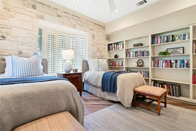 a bedroom with two beds and a book shelf