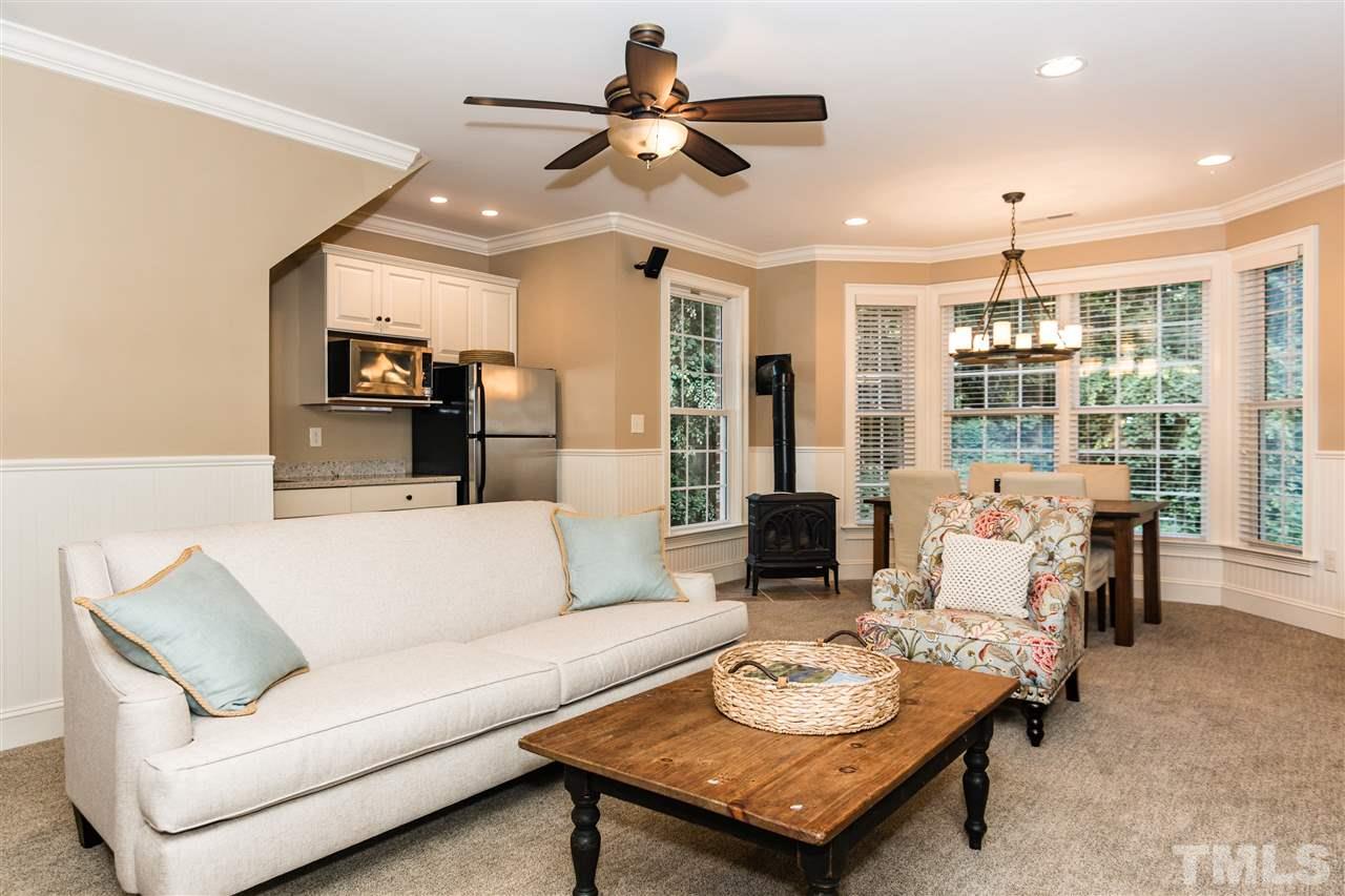 607 Runnymede Road Raleigh, NC 27607 - Photo 20 of 25 a living room with furniture a ceiling fan and a chandelier