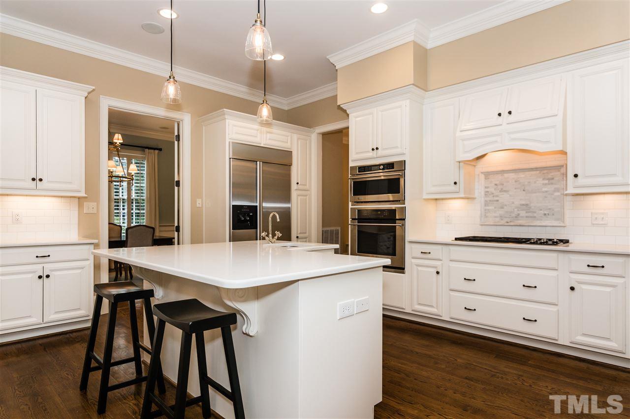 607 Runnymede Road Raleigh, NC 27607 - Photo 9 of 25 a kitchen with a table chairs microwave and cabinets