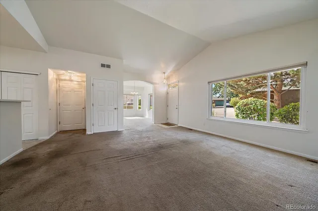 a view of a big room with window and brick walls