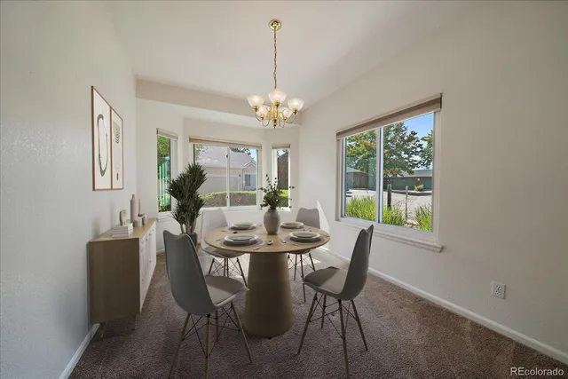 a view of a dining room with furniture a chandelier and wooden floor