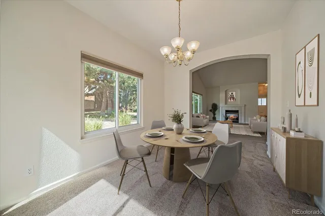 a view of a dining room with furniture a chandelier and wooden floor