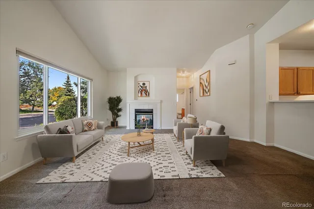 a living room with furniture large window and a fireplace