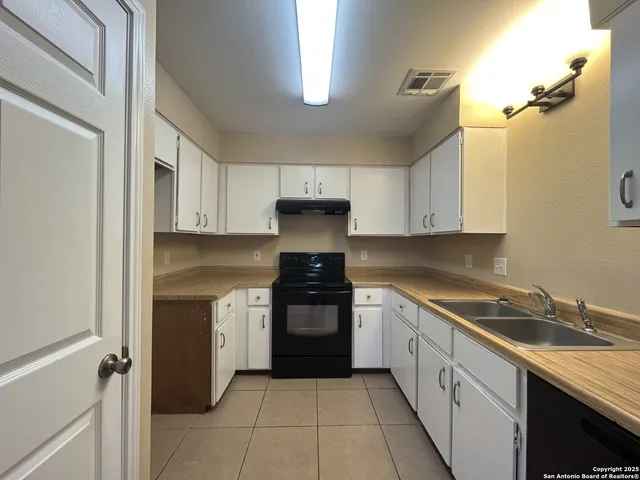 a kitchen with a sink stove and cabinets