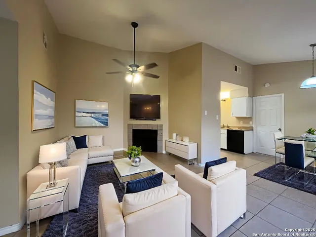 a living room with furniture a fireplace and a chandelier