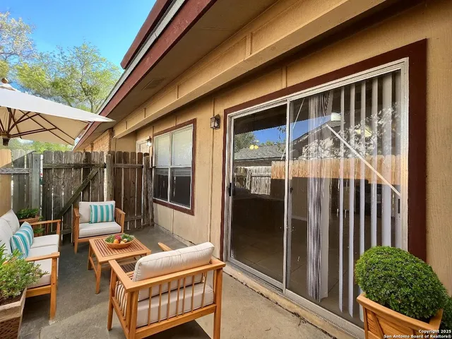 a backyard of a house with barbeque oven table and chairs