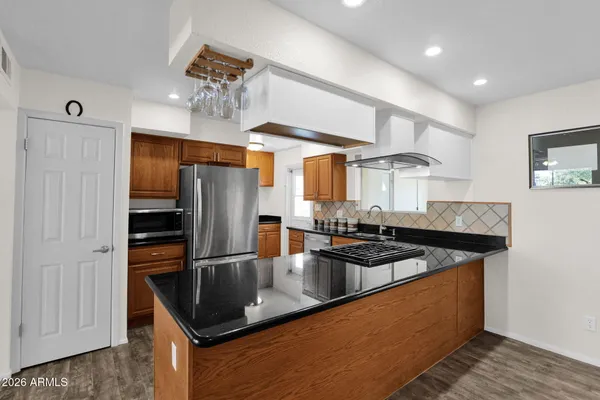a kitchen with granite countertop a refrigerator stove and oven