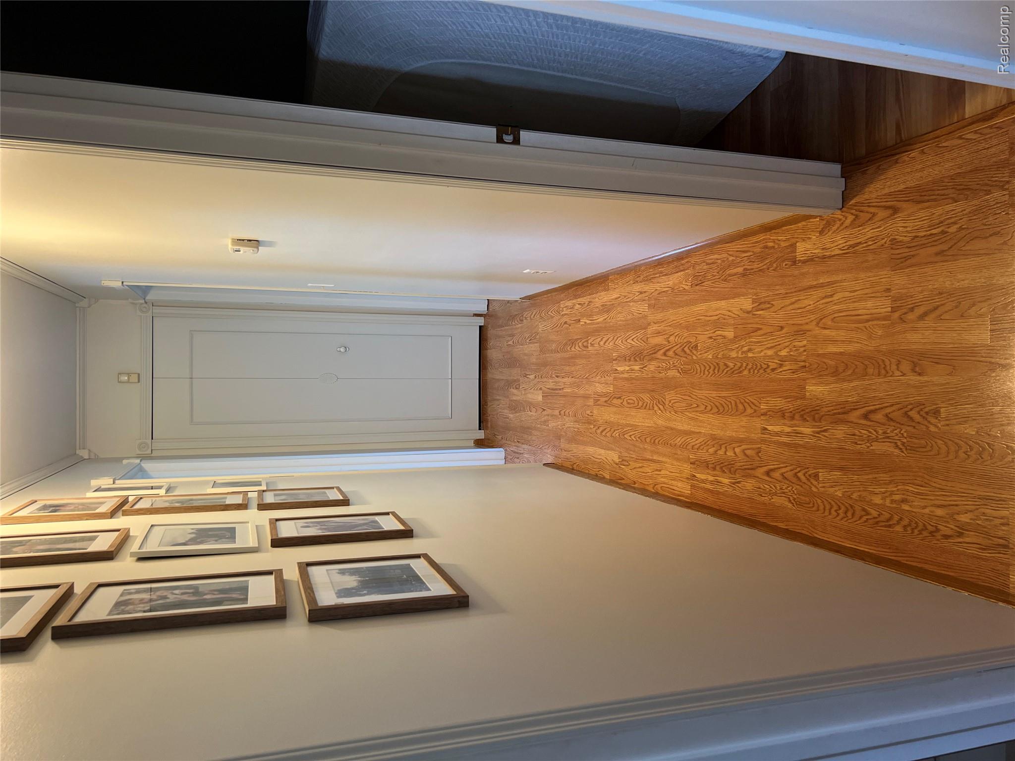 5417 North Road North Street, MI 48049 - Photo 9 of 30 Hallway featuring wood-finish flooring, light-toned walls, and a bi-fold closet door