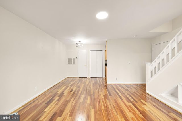 a view of a room with wooden floor and white walls