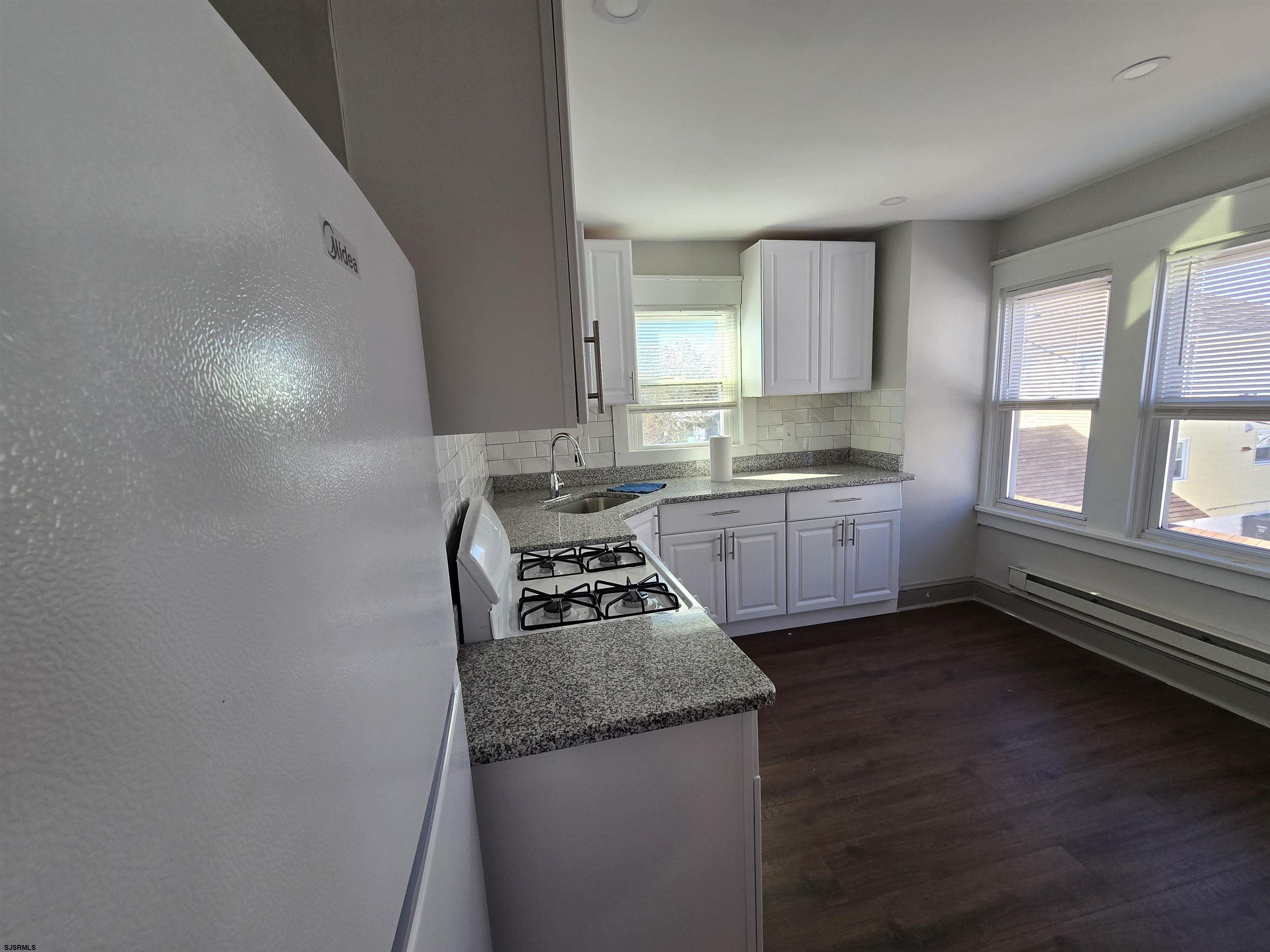 1528 Madison Avenue, Unit B Atlantic City, NJ 08401 - Photo 8 of 12 a kitchen with granite countertop a sink a stove and cabinets