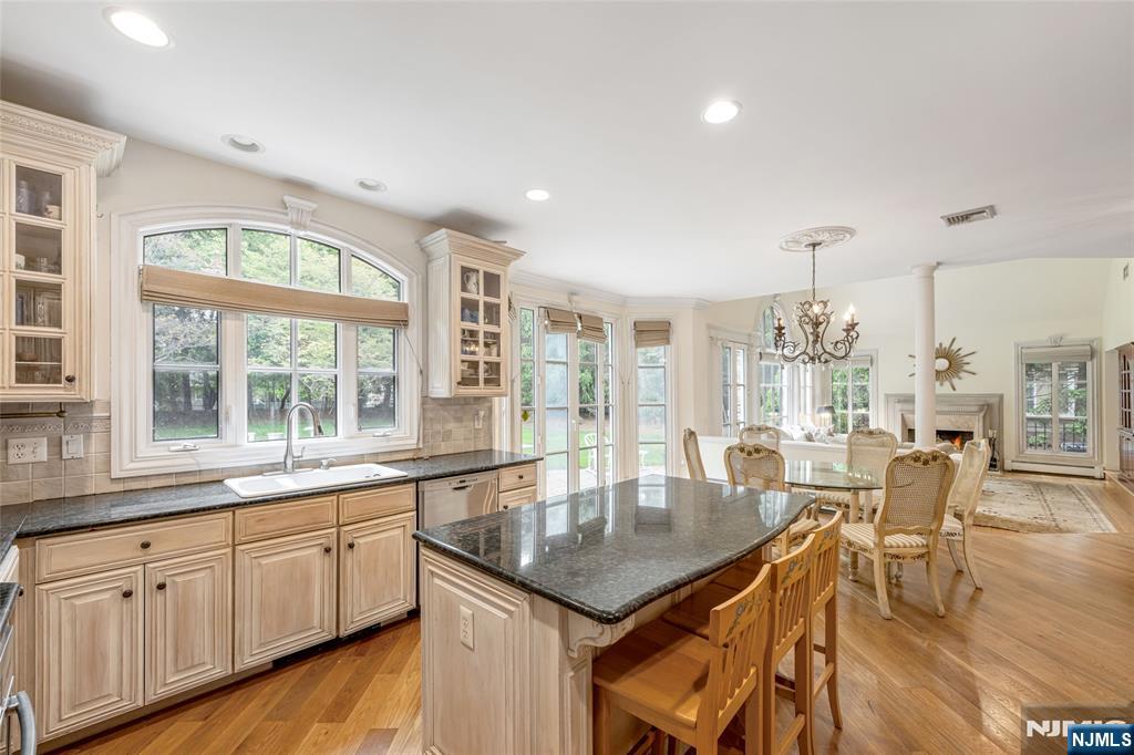 4 Hetzel Drive Mahwah, NJ 07430 - Photo 7 of 29 a kitchen with granite countertop a table chairs stove and wooden floor