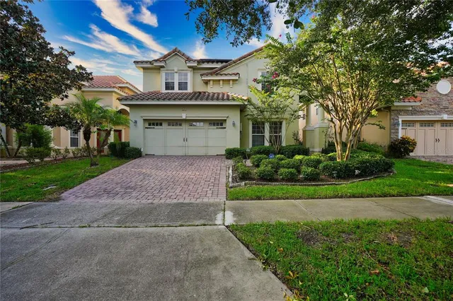 a front view of a house with a garden and tree