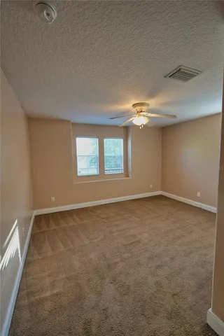 an empty room with a window and a fan