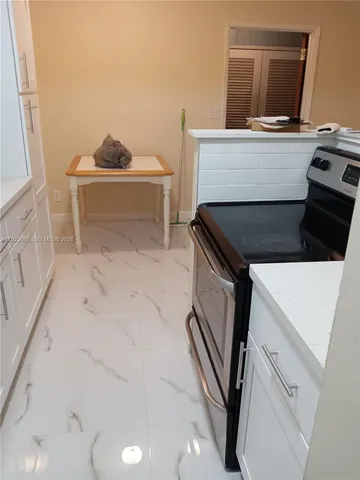a kitchen with a refrigerator sink stove and cabinets