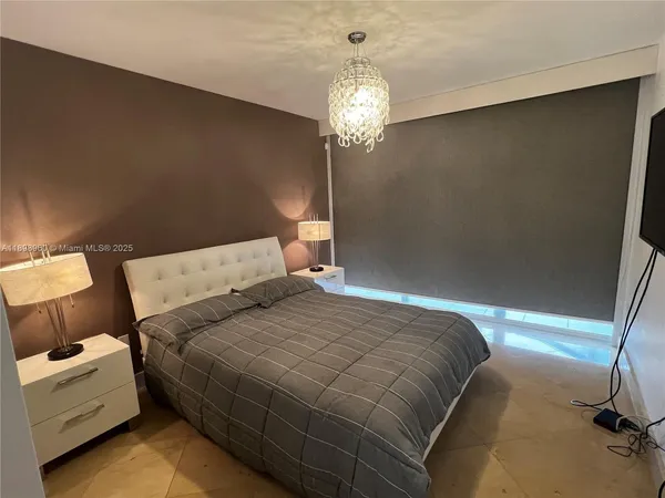 a bedroom with a bed and a chandelier