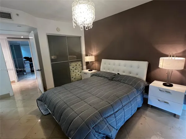 a bedroom with a bed and a chandelier