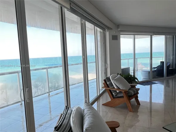 a living room with furniture and a floor to ceiling window