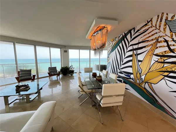 a living room with furniture and floor to ceiling windows