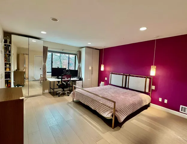 a bedroom with a bed and wooden floor
