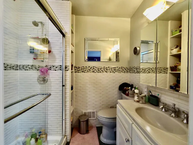 a bathroom with a sink mirror toilet and shower